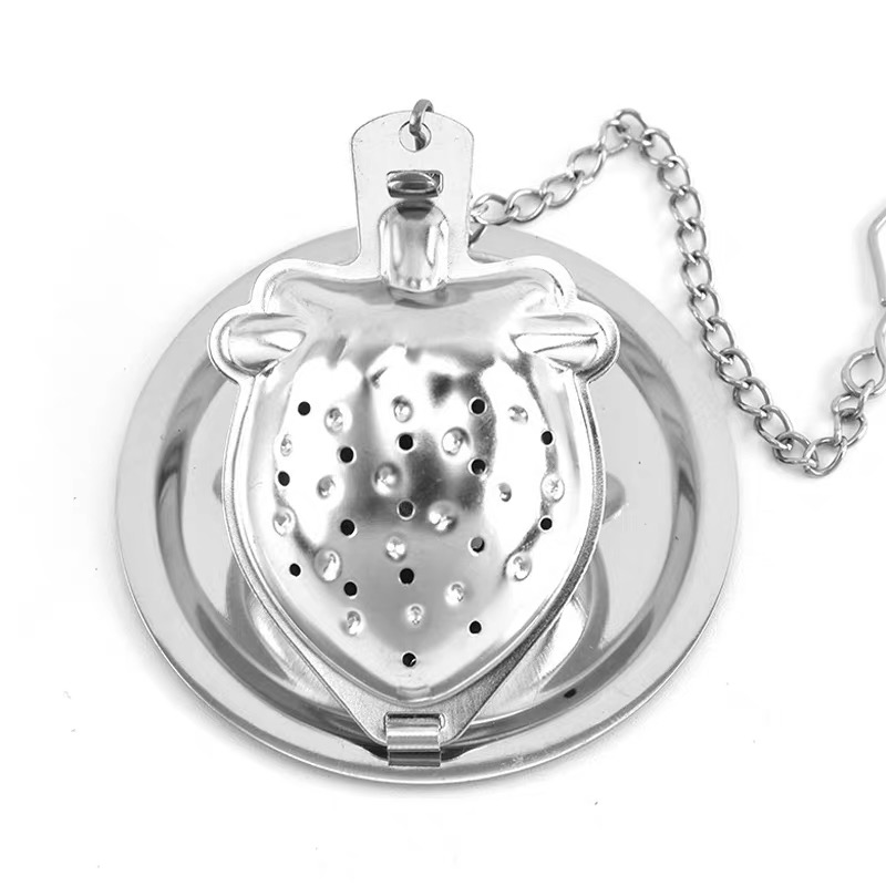 Gold strawberry-shaped tea infuser with a matching saucer and chain Gold strawberry-shaped tea infuser with a matching saucer and chain