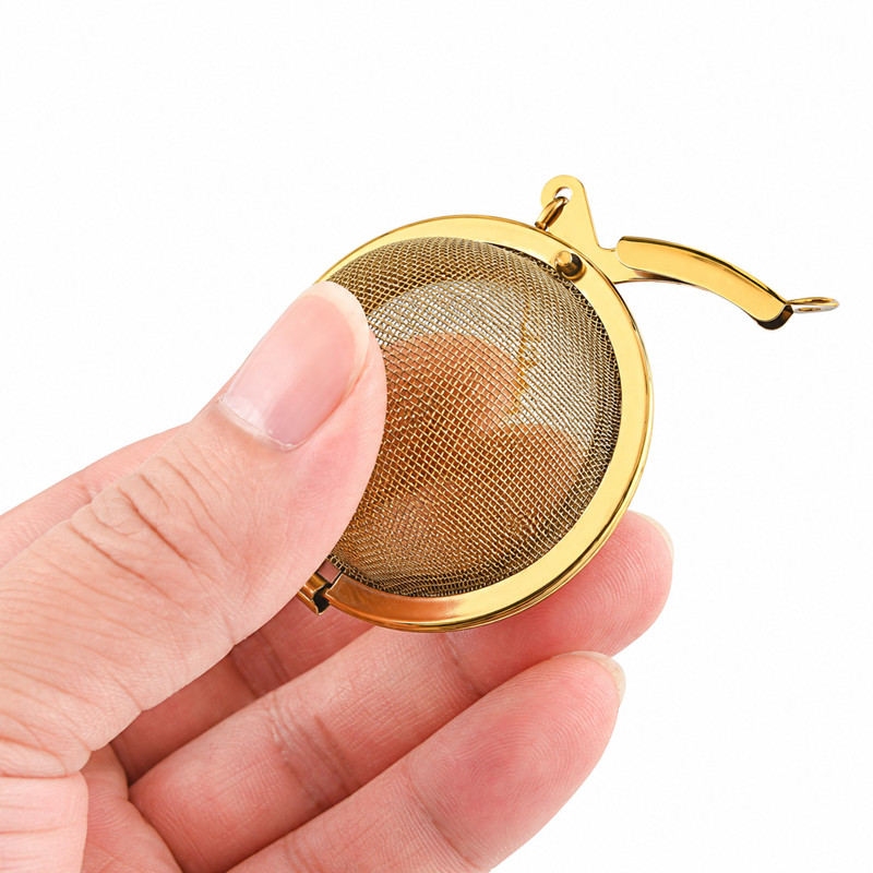 Gold tea infuser with fine mesh basket and decorative chain Gold tea infuser with fine mesh basket and decorative chain