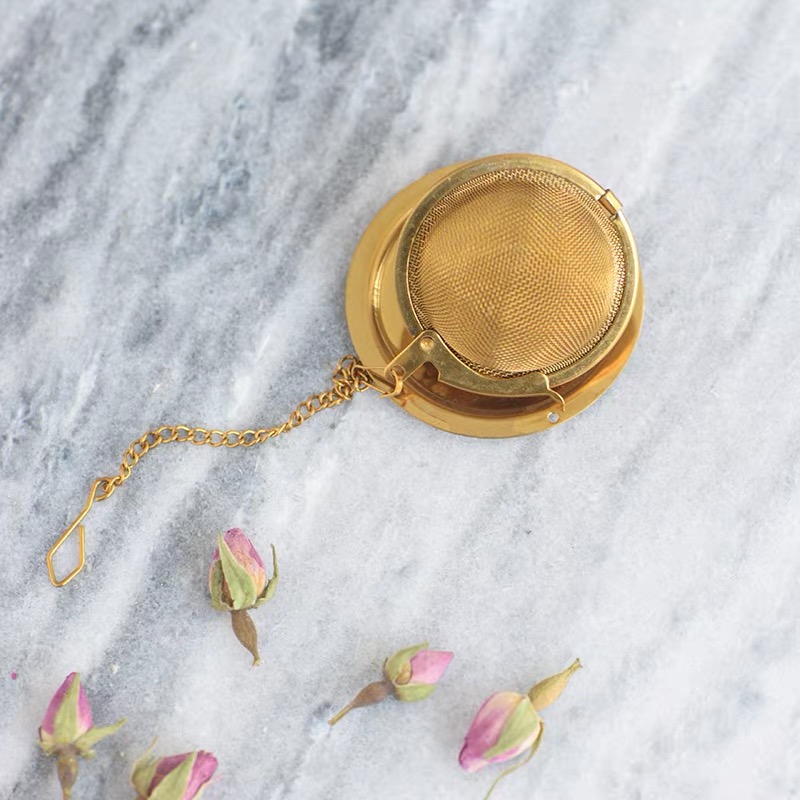 Gold tea infuser with fine mesh basket and decorative chain Gold tea infuser with fine mesh basket and decorative chain