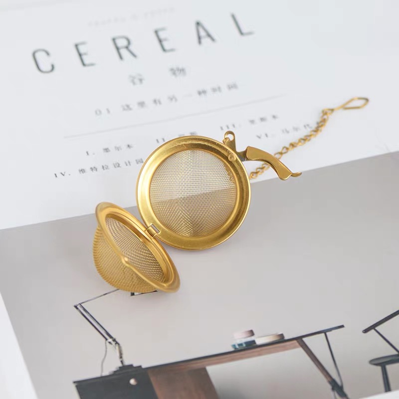 Gold tea infuser with fine mesh basket and decorative chain Gold tea infuser with fine mesh basket and decorative chain